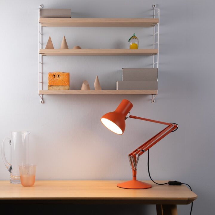 type 75 mini desk lamp orange zest on desk with shelf behind